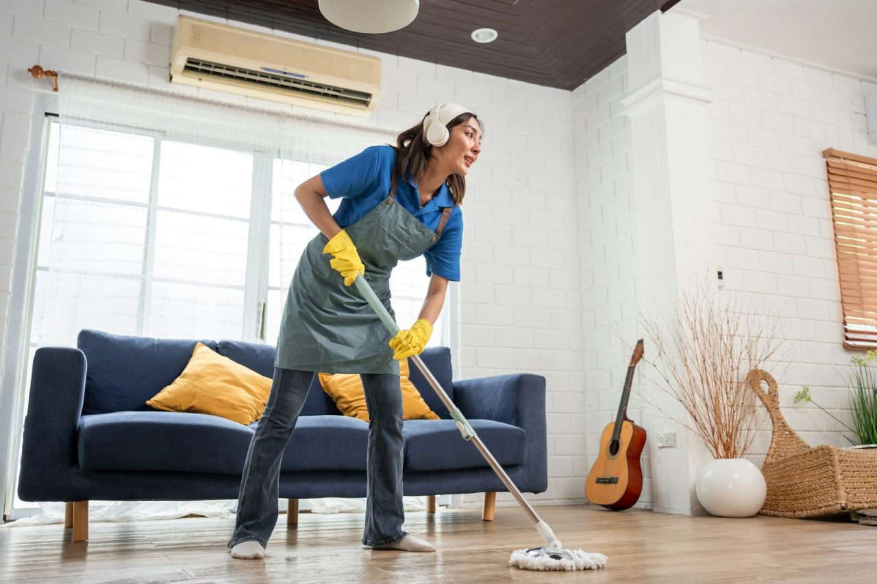 beautiful woman cleaner cleaning indoors in living room at home.