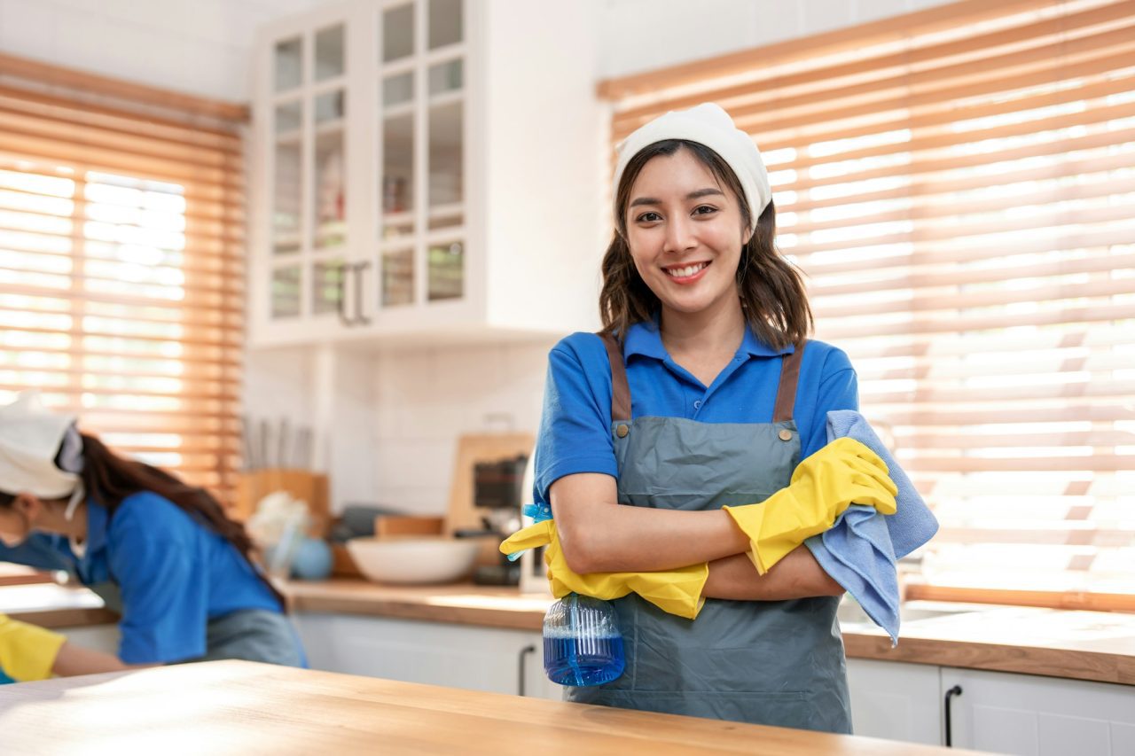 Portrait of Asian cleaning service woman worker working in the kitchen.